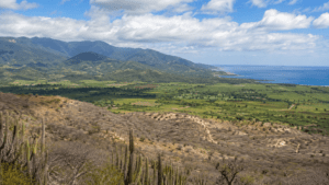 Panoramic view showing the Dominican Republic's diverse landscapes, from lush mountains to dry valleys and tropical coastline.