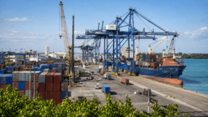 Commercial container port in the Dominican Republic with cargo cranes, shipping containers, trucks and a cargo vessel