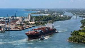 Cargo ship entering a dredged river channel at a Dominican Republic coastal port